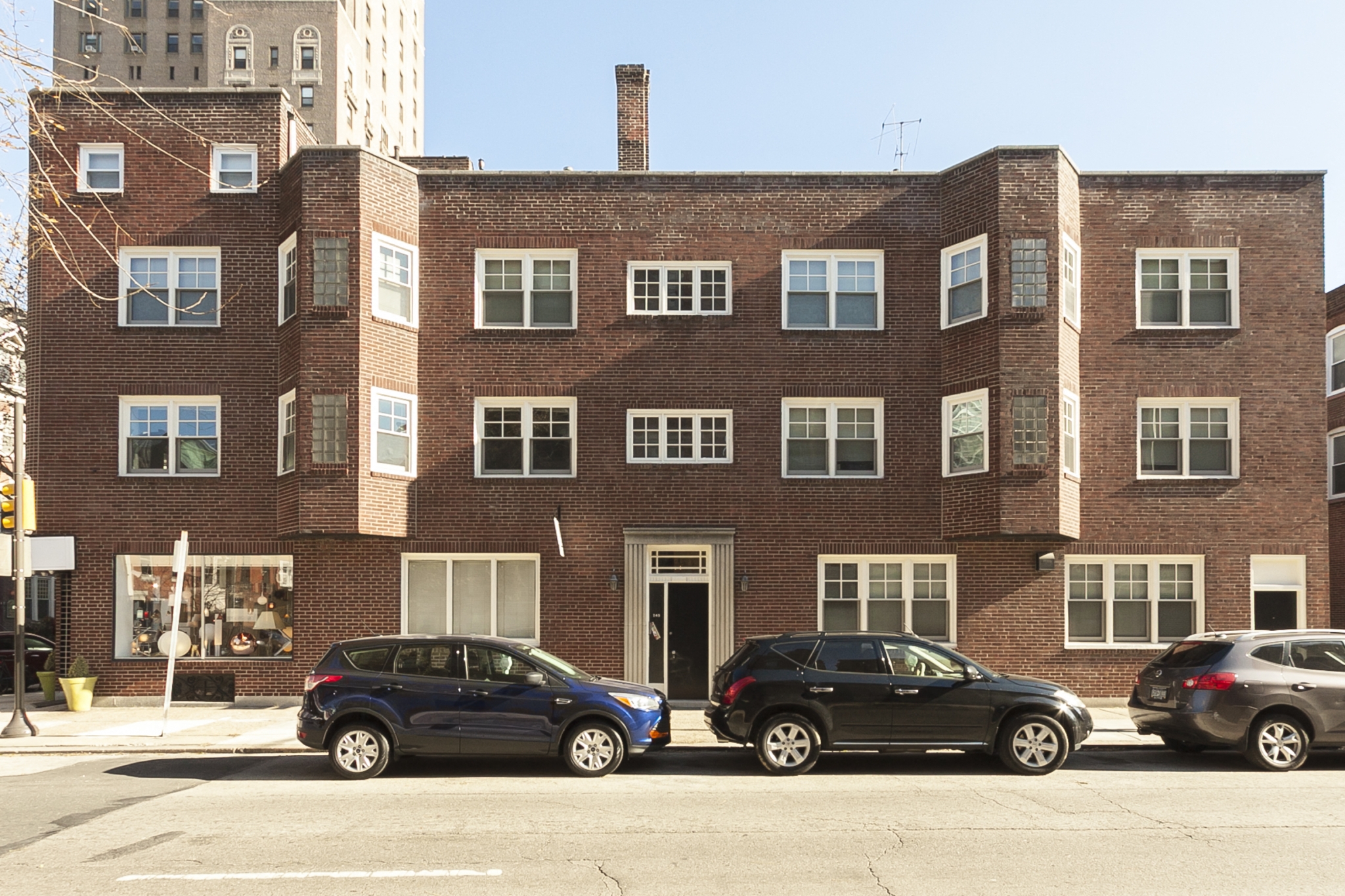 a brick building with three cars parked in front of it